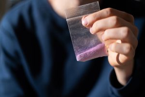 drug addict hands holding a small package with white powder