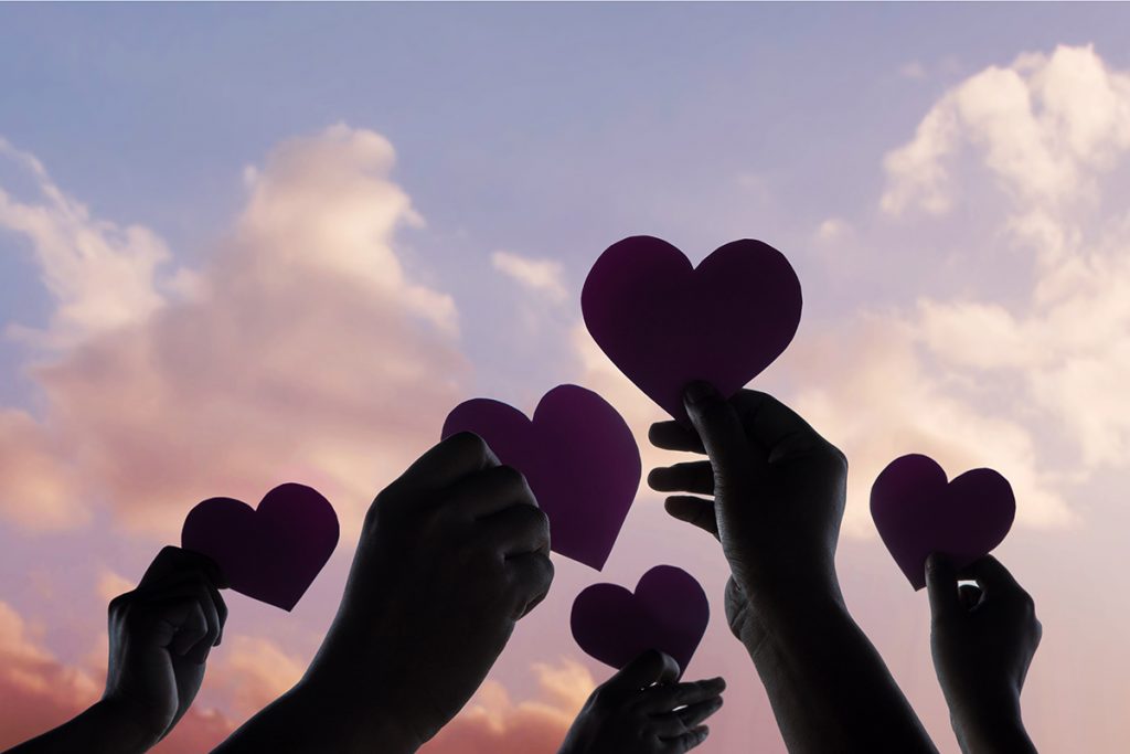Love, Freedom and Charity Concept. Group of Diversity Volunteer People Raise Up Heart Paper Shape into the Sky